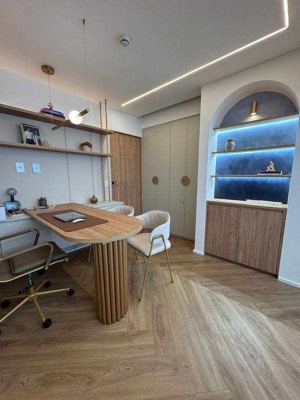 Consultório de dermatologia em Santos, com mesa de atendimento, cadeiras e nicho iluminado
