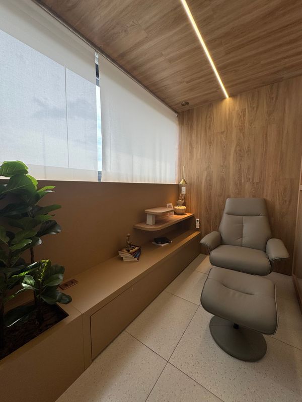Ambiente reservado com poltrona reclinável, jardim interno e iluminação suave