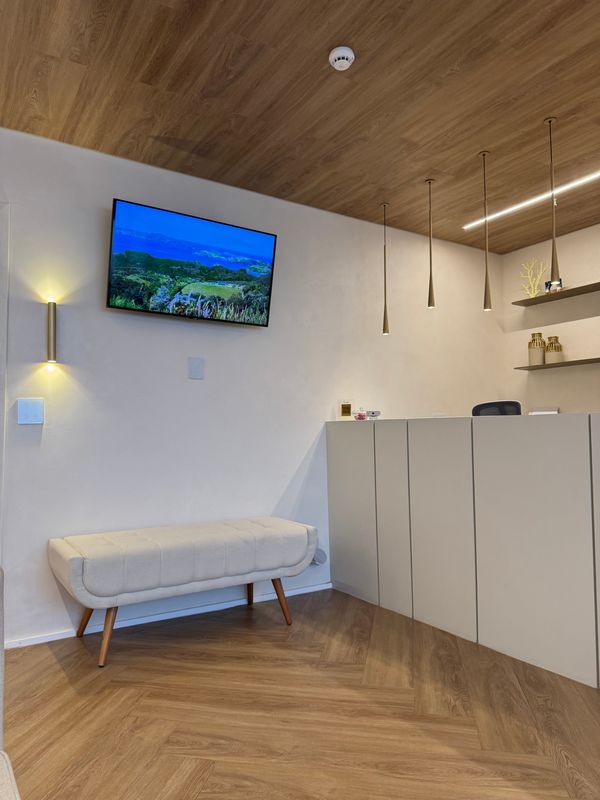 Recepção do consultório, com banco estofado e balcão de atendimento